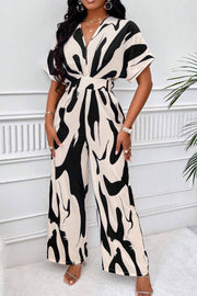 Abstract brushstroke wide-leg jumpsuit in black and taupe with a V-neck and short sleeves.