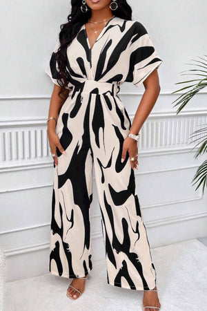 Abstract brushstroke wide-leg jumpsuit in black and taupe with a V-neck and short sleeves.
