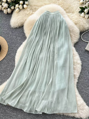 Light green pleated maxi skirt with flowing fabric and subtle vertical texture.