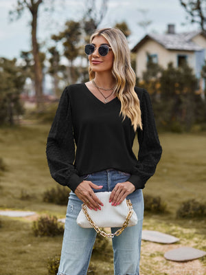 Black V-neck blouse with Swiss dot textured bishop sleeves and a relaxed fit.