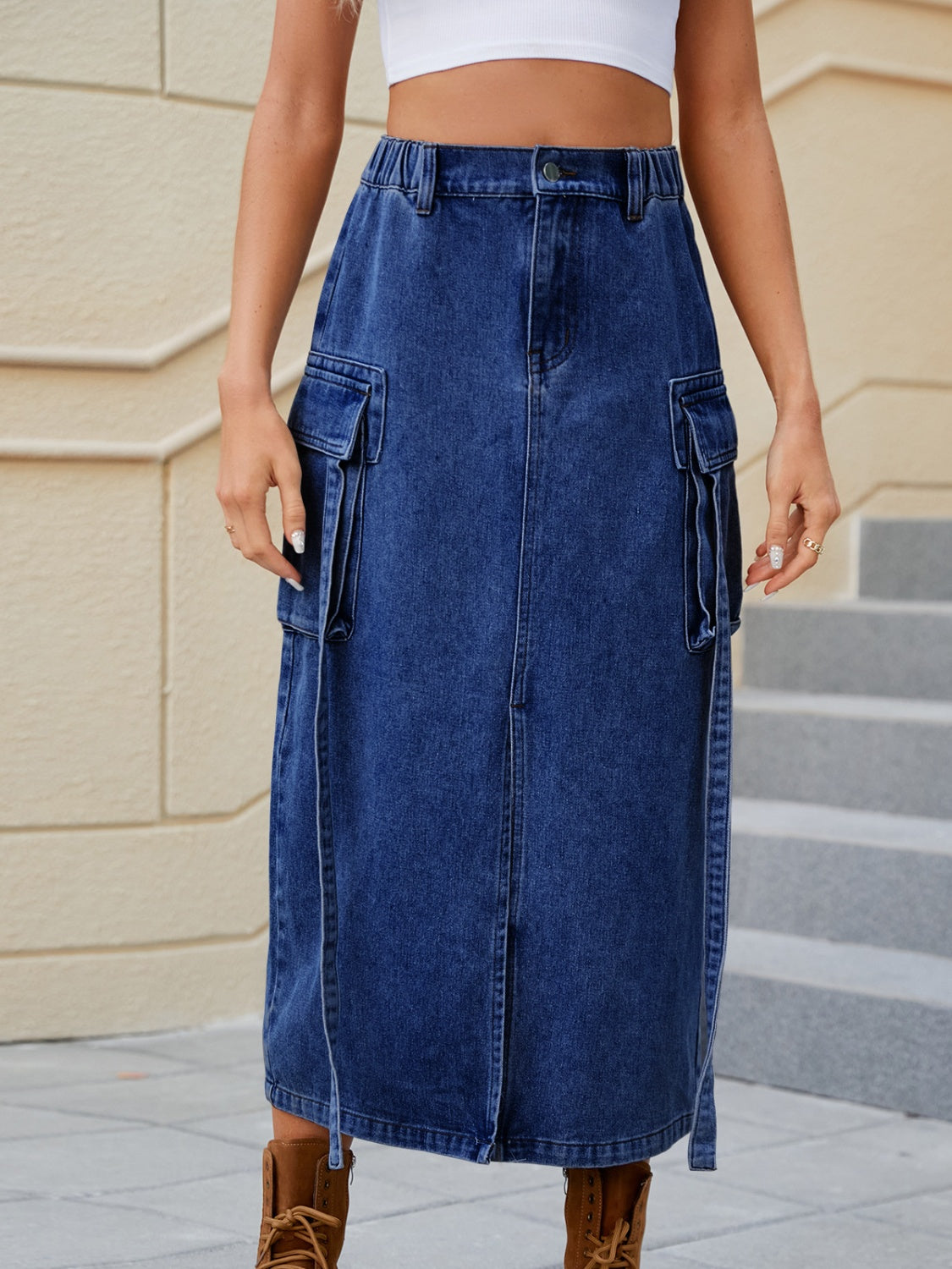 Dark blue denim midi skirt with cargo pockets and a front slit.