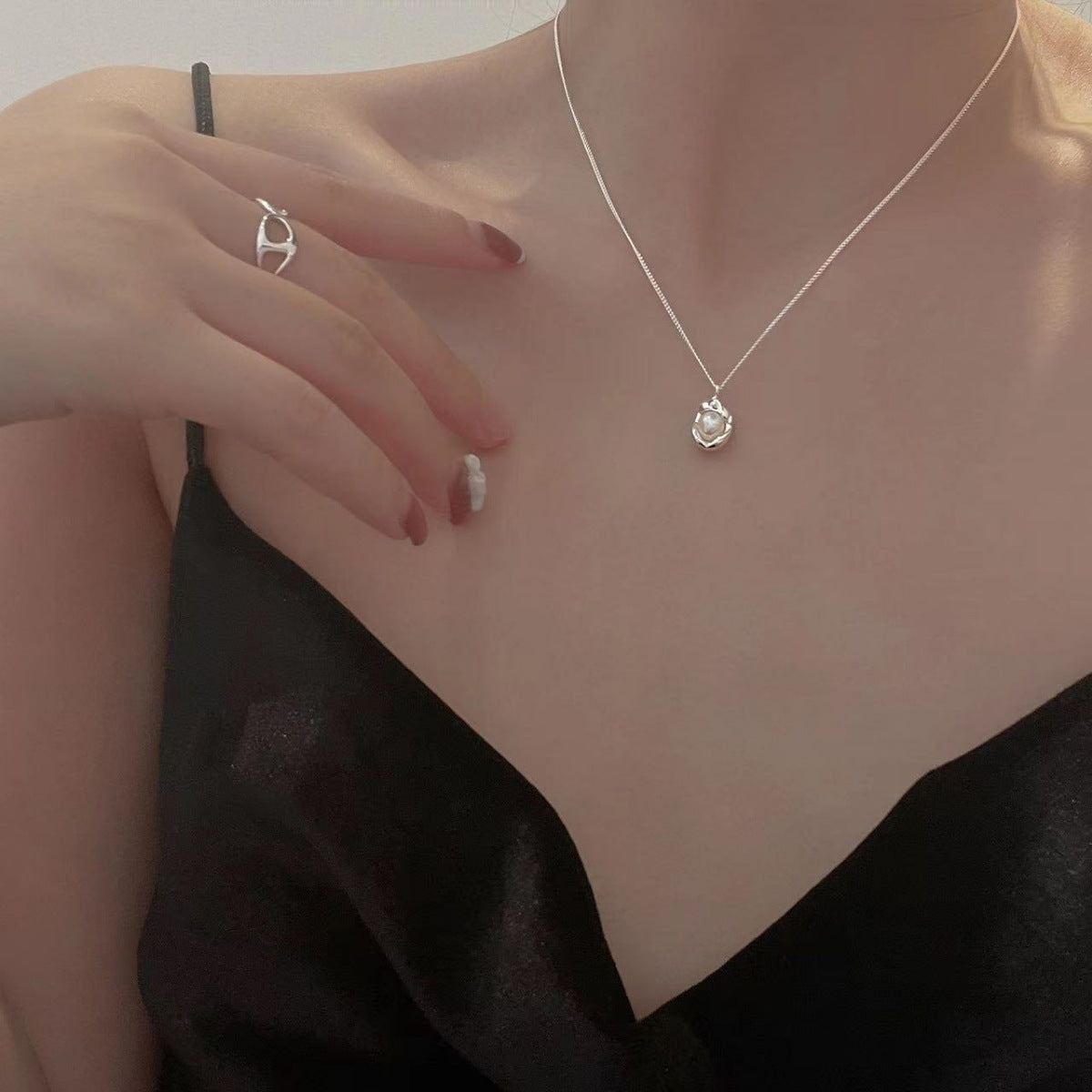 Sterling silver pendant necklace with a pearl, worn with a black satin camisole.