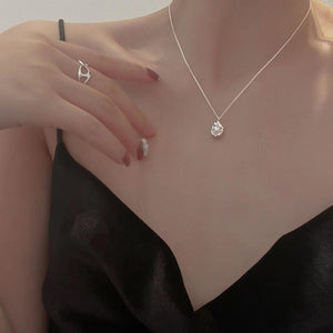 Sterling silver pendant necklace with a pearl, worn with a black satin camisole.