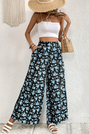 Midnight Floral Palazzo Trousers with a black base and blue floral print, featuring a wide leg and pockets.
