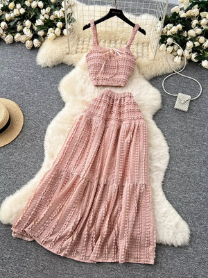 Pink ruched crop top and tiered maxi skirt set with tie detail.