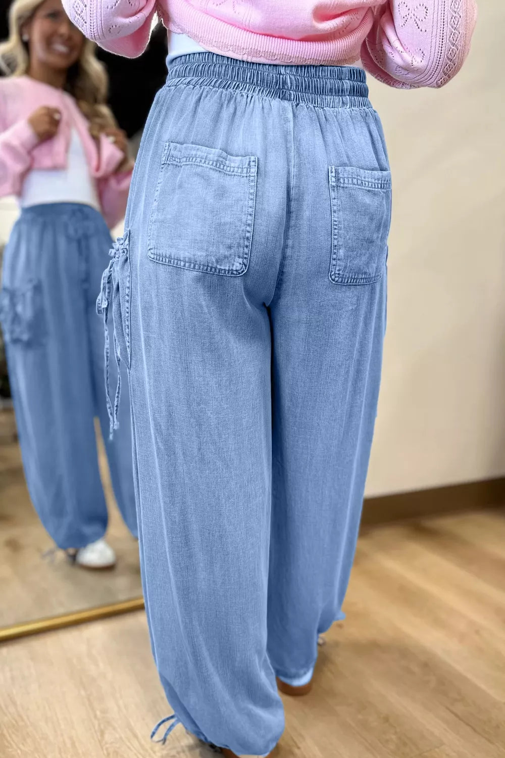 Light blue denim maternity cargo jeans with drawstring waist and cinched ankles.