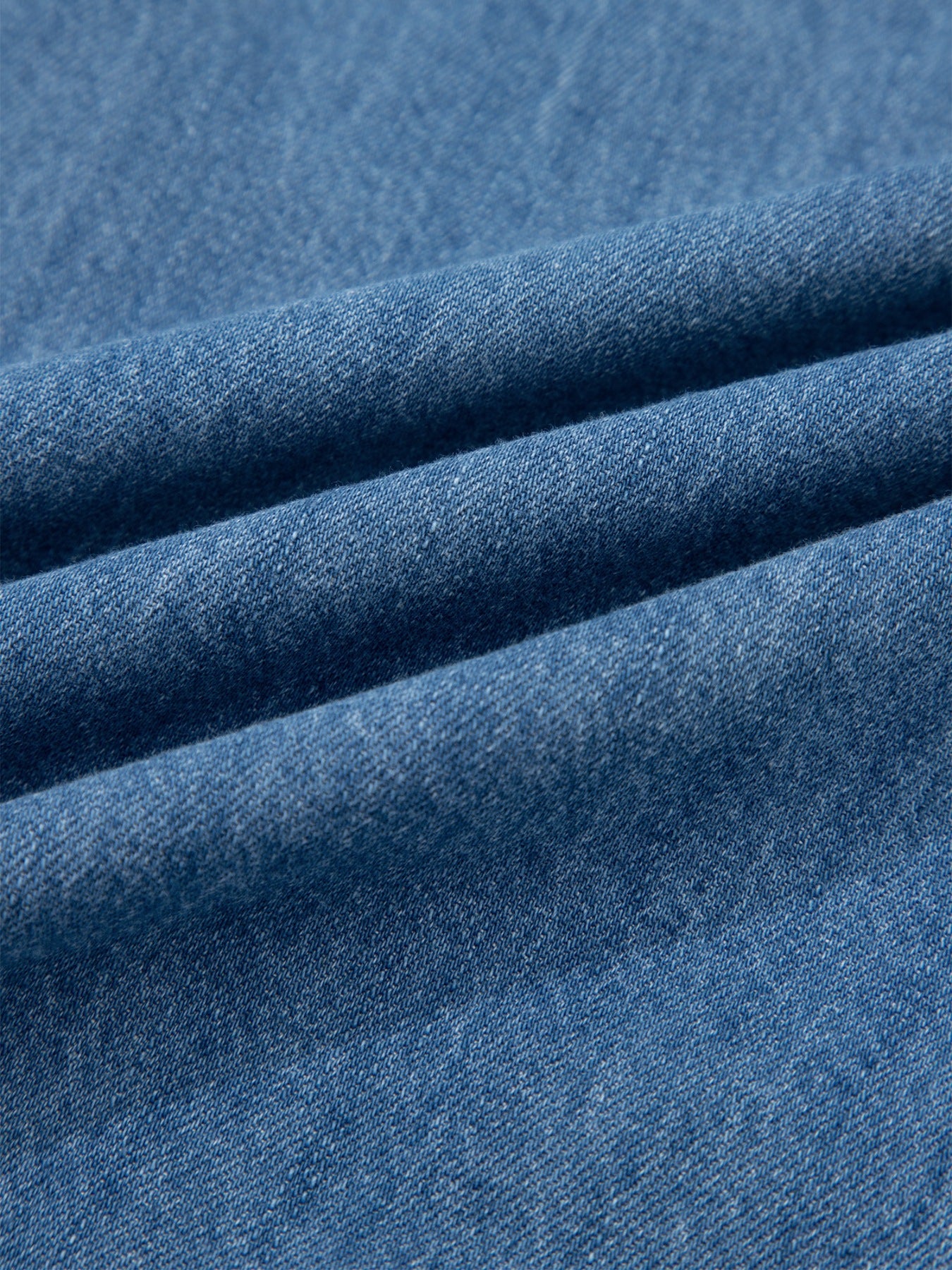 Blue denim fabric with visible texture and folds.