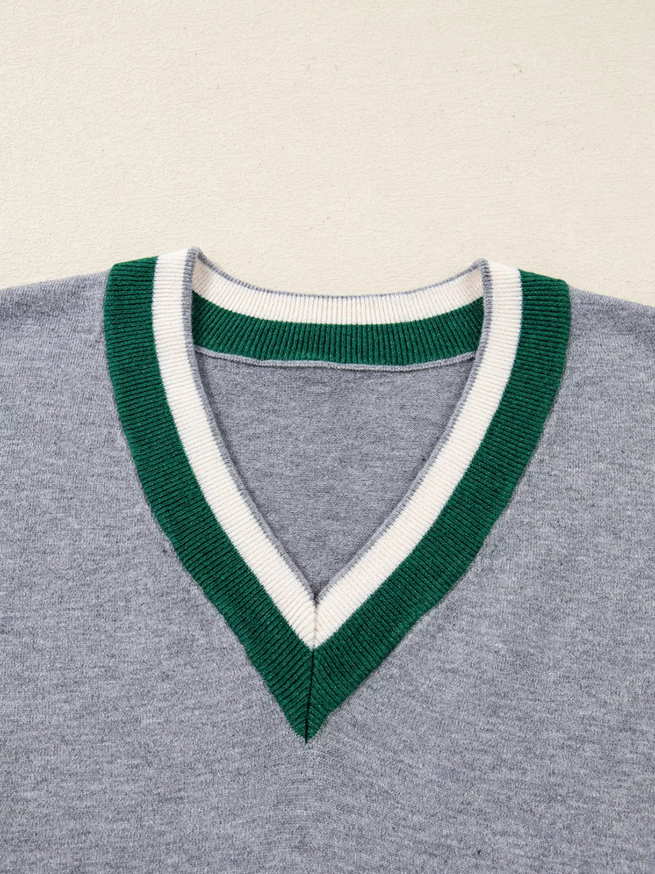 Gray ribbed V-neck sweater with green and white striped trim