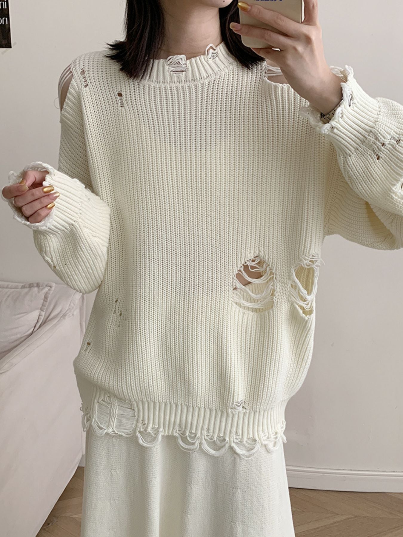 Off white distressed cotton sweater with deconstructed details and frayed hem.