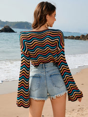 Multicolor wave-stripe crochet cropped sweater with bell sleeves.