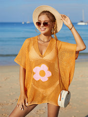 Orange crochet beach cover-up with pink and orange flower appliqué, V-neck, short sleeves.