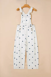 White denim overalls with navy polka dots, buttoned sides, and adjustable straps.