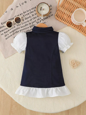 Navy polo dress with white ruffled hem and puff sleeves.