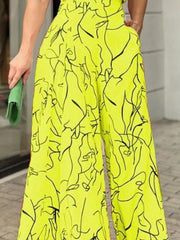Canary yellow halter neck romper with abstract black line art print and wide legs.