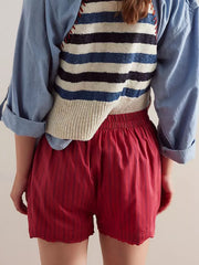 Scarlet boxer shorts with thin navy pinstripes and a scalloped hem.