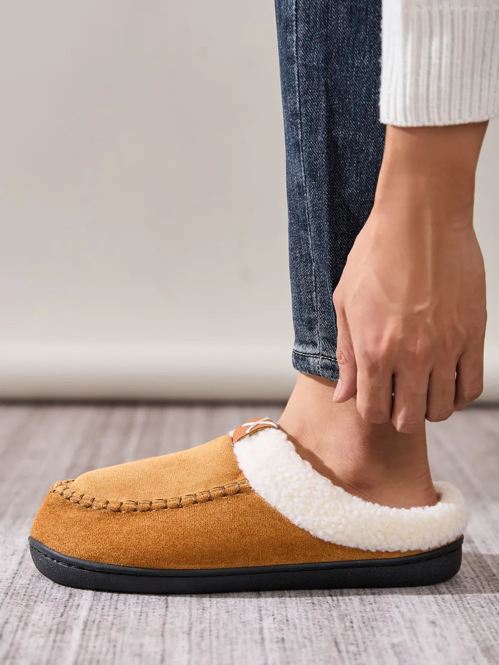 Caramel suede moccasin slides with white shearling lining and decorative stitching.