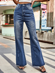 Dark blue denim flare jeans with distressed details and a buttoned fly.