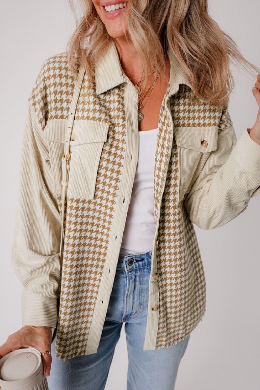 Beige houndstooth corduroy patchwork shacket with button pockets and corduroy sleeves.