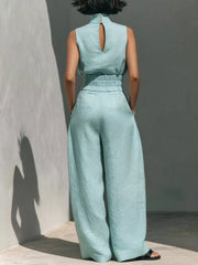 Sky blue sleeveless turtleneck set with wide-leg pants and button detail at back neck.