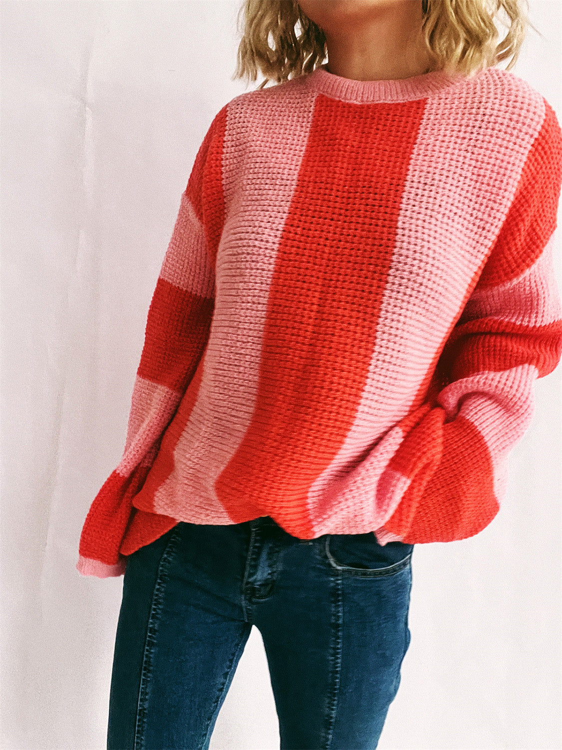 Vertical stripe waffle knit sweater in orange-red and pink acrylic with crew neck.