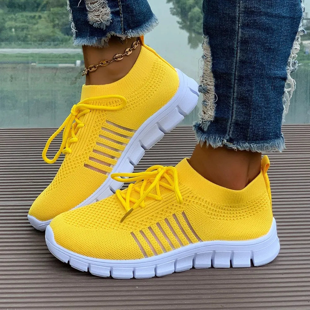 Yellow knit runner sneakers with white soles and stripe detail.