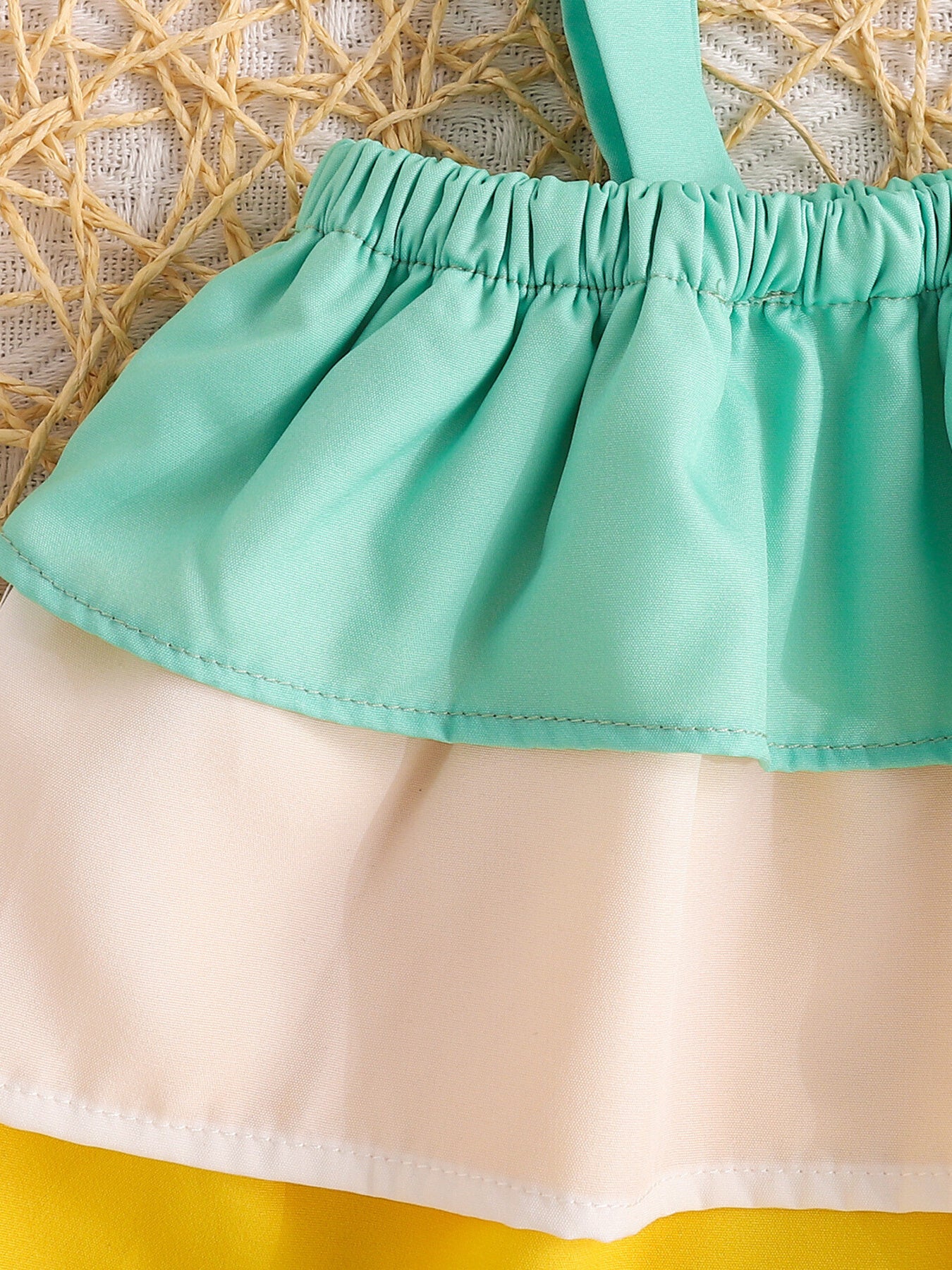 Baby cami with ruffled mint green tier over cream fabric, part of a set.