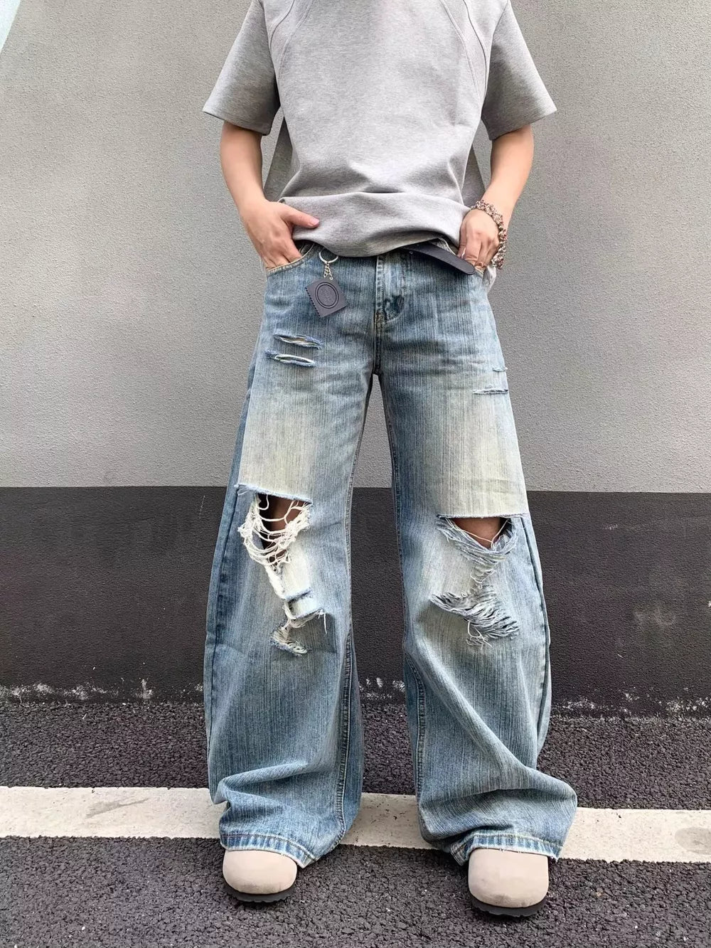 Distressed wide-leg jeans in light wash denim with pocket detail and baggy fit.