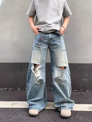 Distressed wide-leg jeans in light wash denim with pocket detail and baggy fit.