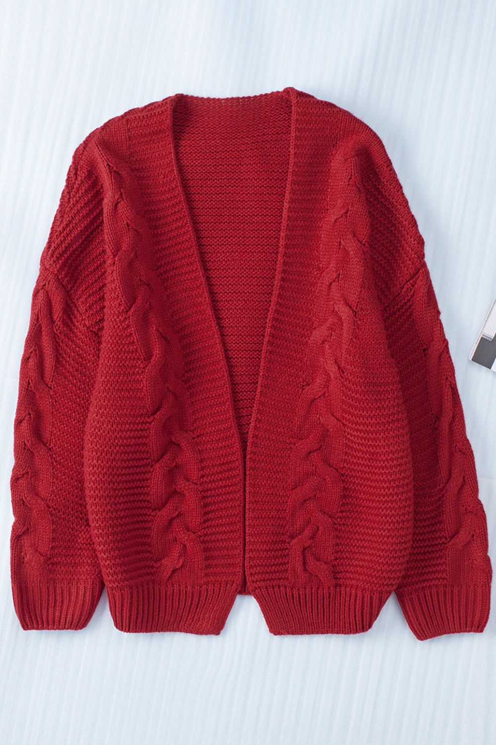 Burgundy cable knit open-front cocoon cardigan with textured sleeves.