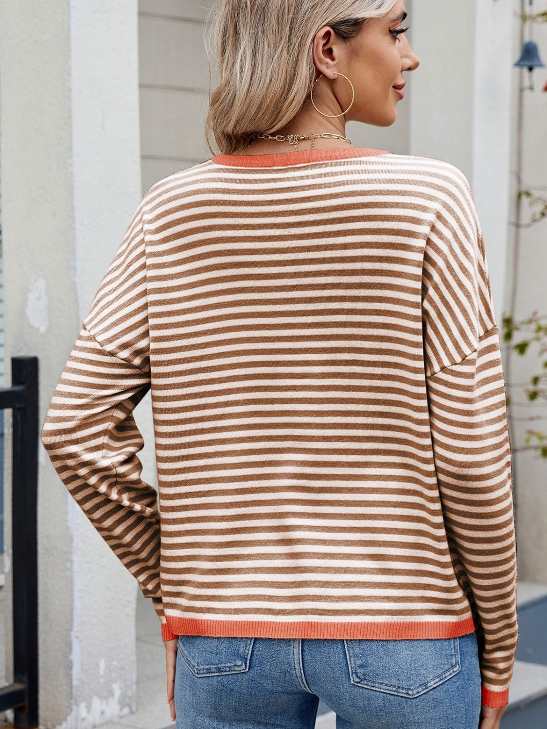 Caramel and white striped knit sweater with contrast trim and drop shoulders.