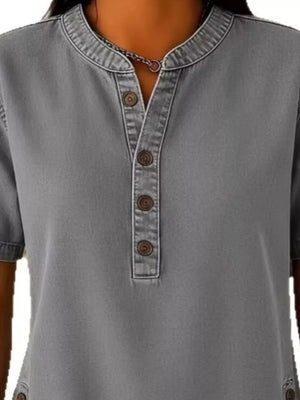 Grey denim-inspired short sleeve button blouse with band collar and button detail.