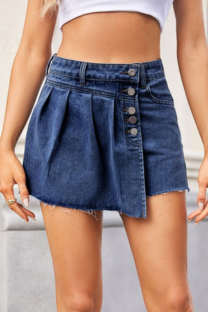 Denim skort with asymmetric pleats, button front, and frayed hem in dusty blue.