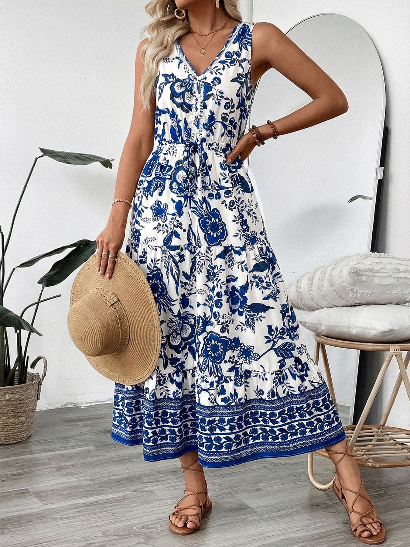 Charming floral midi dress in dark blue and white with V-neck, drawstring waist, and tiered skirt.