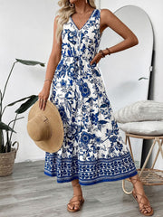 Charming floral midi dress in dark blue and white with V-neck, drawstring waist, and tiered skirt.