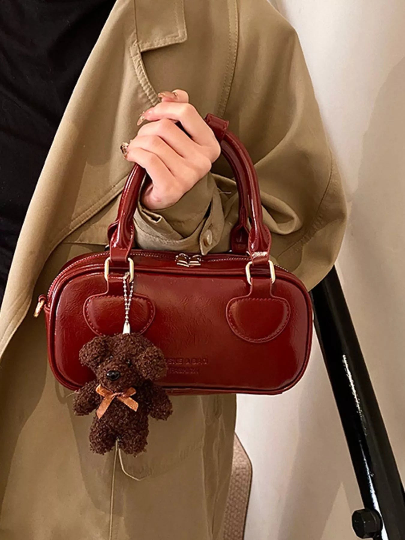 Chic mini crossbody bag in deep red patent PU leather with a teddy bear charm.
