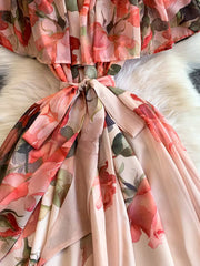 Botanical off-shoulder dress in light pink with floral print and belted waist detail.