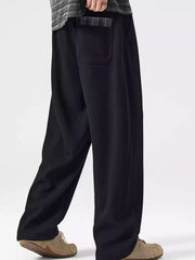 Black loose-fit men's sweatpants with a plaid pocket detail.