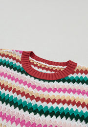 Textured knit sweater with multicolor chevron stripes and contrast red trim neckline.