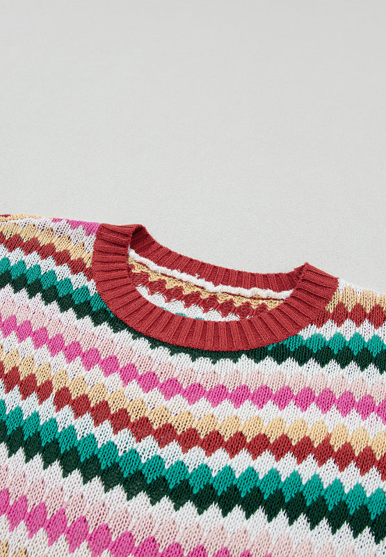Textured knit sweater with multicolor chevron stripes and contrast red trim neckline.