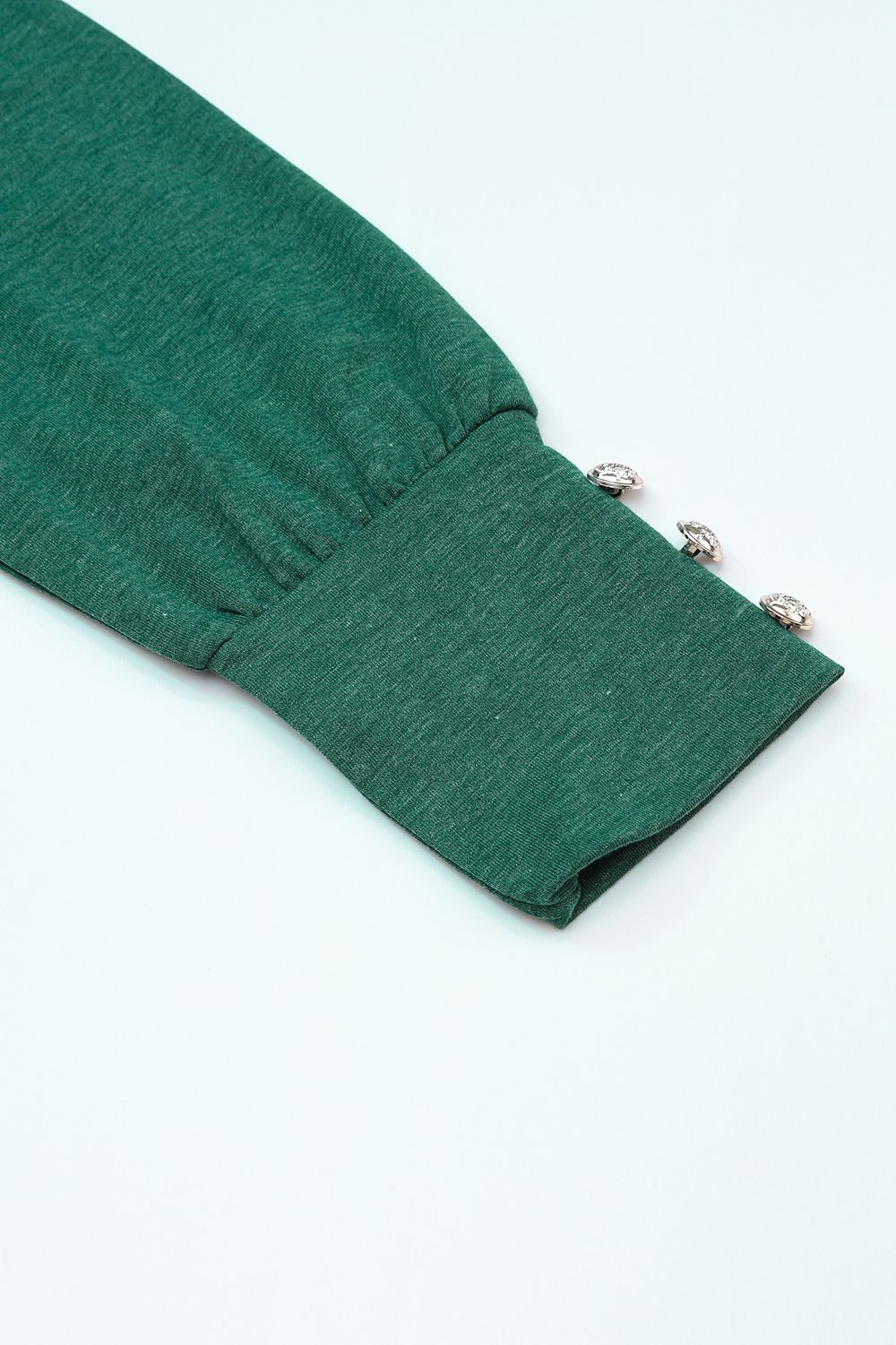 Dark green top sleeve detail with button cuffs