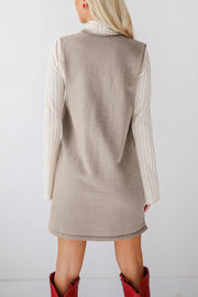 Sleeveless knit dress in camel with V-neck, layered over a striped long-sleeve top.