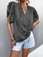 Black ditsy print blouse with ruffle sleeves and V-neck, cinched waist detail.