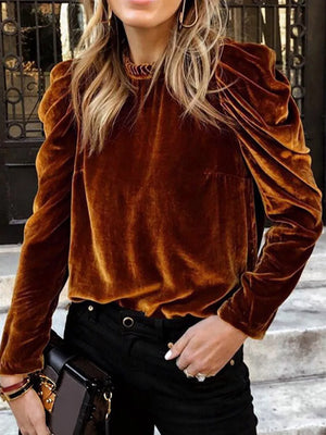 Brown velvet mock neck blouse with ruffled puff sleeves and textured neckline.