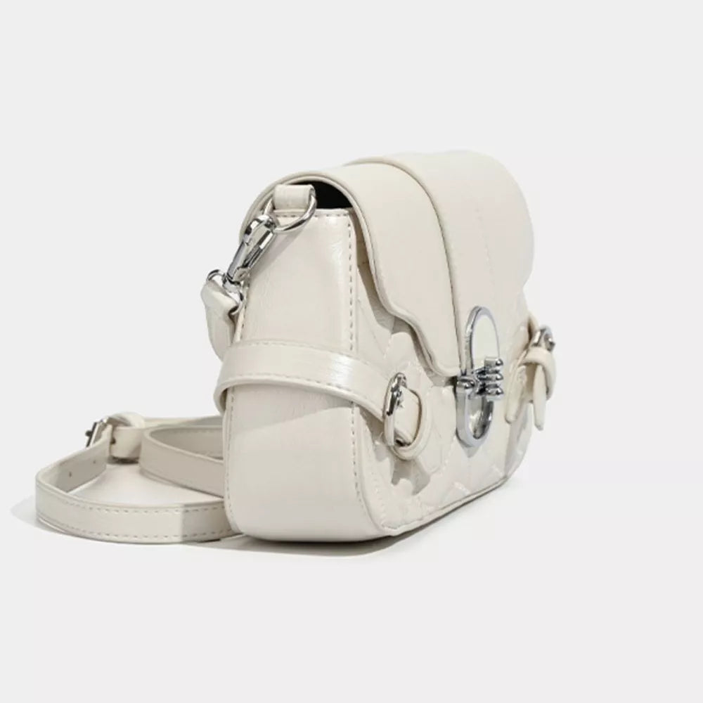 White heart-quilted crossbody bag with buckle accent and silver hardware.