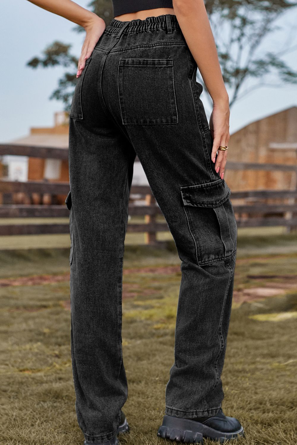Black denim cargo pants with utility pockets and elastic waistband.