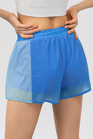 Colorblock performance running shorts in blue with elastic waistband and lightweight fabric.