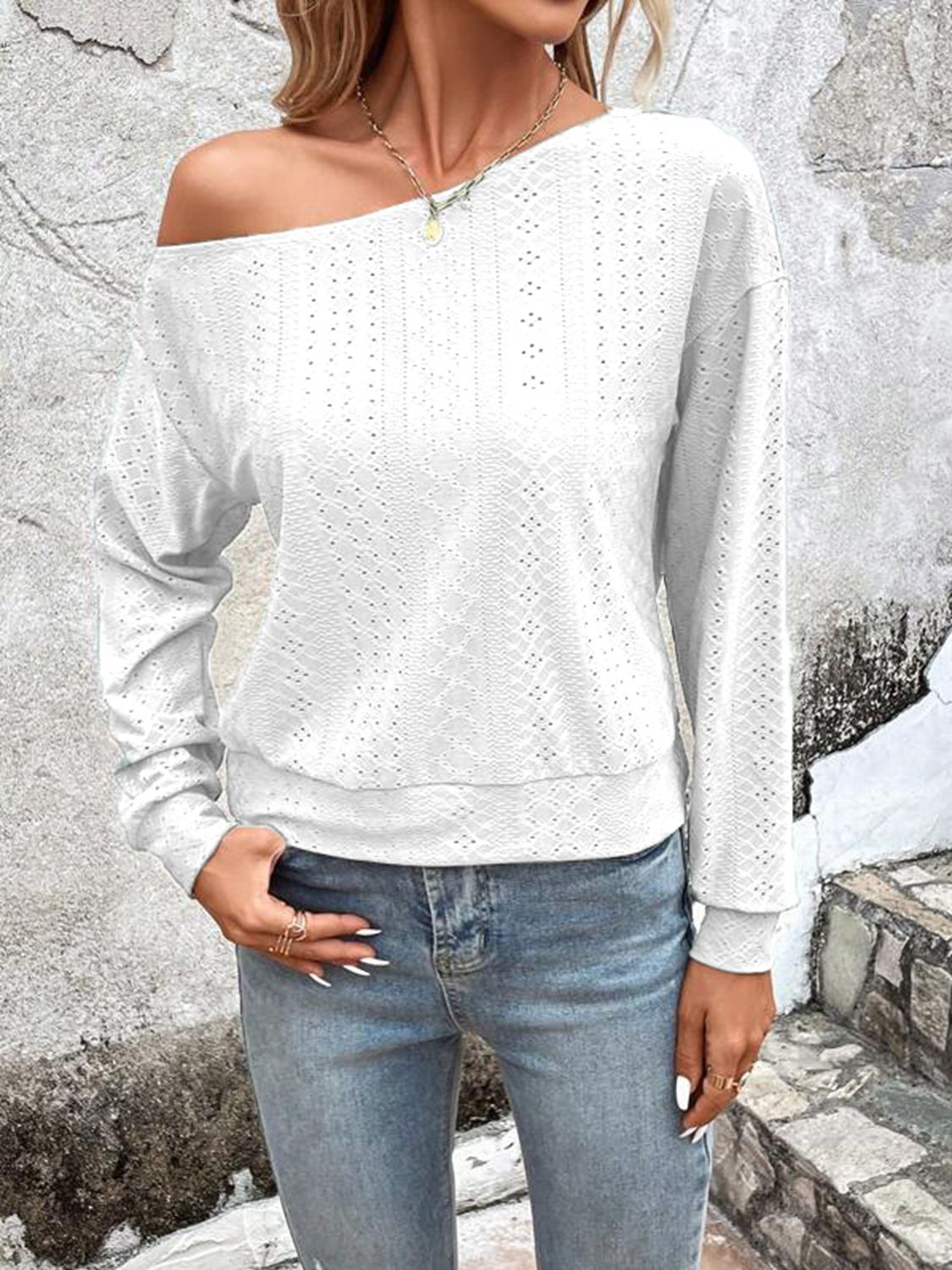White off-shoulder eyelet knit blouse with long sleeves and a relaxed fit.
