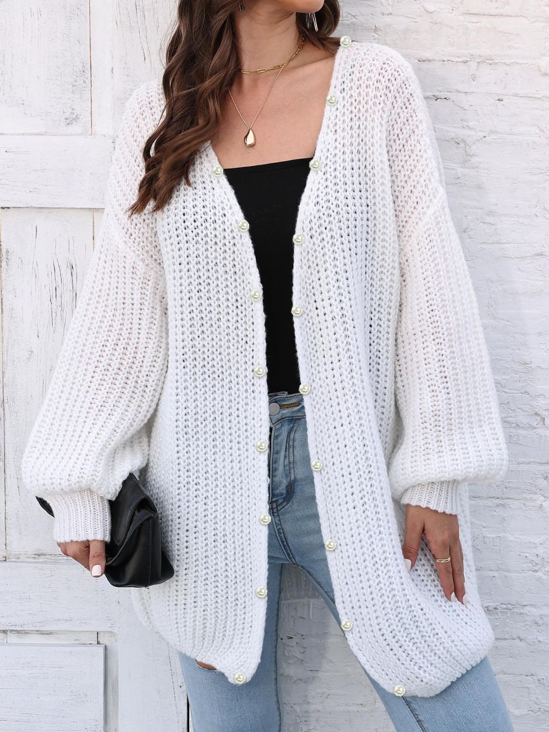 White balloon sleeve cardigan with pearl buttons, V-neck, and textured knit.