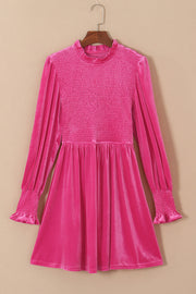 Hot pink velvet mini dress with smocked bodice, ruffled neckline, and smocked cuffs.