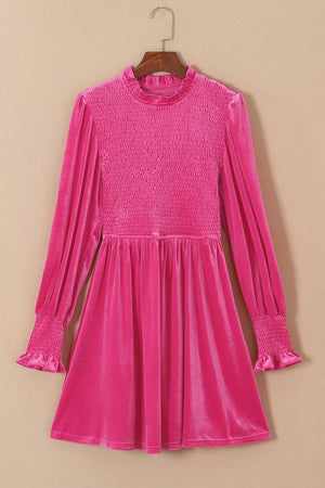 Hot pink velvet mini dress with smocked bodice, ruffled neckline, and smocked cuffs.